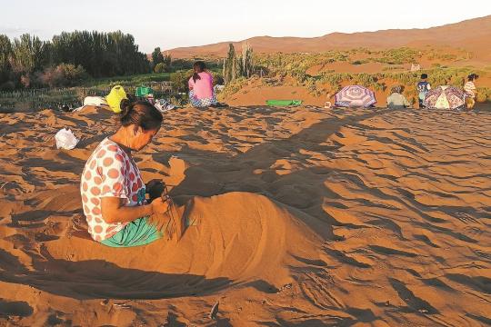 Sand therapy turns Xinjiang's deserts into a tourist magnet