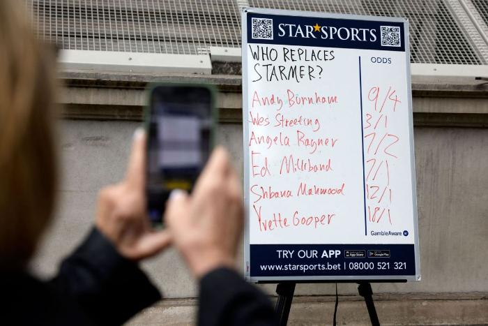 People take photographs of a betting company's odds on contenders to be the next leader of Britain's Labour party, with Andy Burnham, Wes Streeting and Angela Rayner's names all listed, on Whitehall in central London on May 12, 2026. (Photo/Agencies)