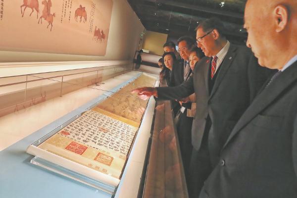 Visitors admire Li Gonglin's scroll at the ongoing exhibition Divine Steeds: The World of Horses in the Palace Museum's Painting and Calligraphy Collections at the Palace Museum in Beijing. (Photo: Jiang Dong/China Daily)