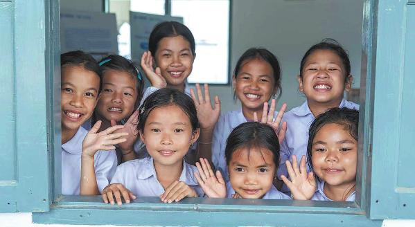 Children peer through a window of a small library built by China International Water & Electric Corp in Thinsom village, Luang Prabang province, Laos. (Photo: China Daily)