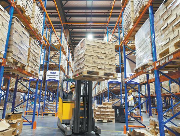 Employees arrange imported products at a warehouse in Jinhua, Zhejiang province, on June 18. (Photo: Pan Qiuya/ China Daily)