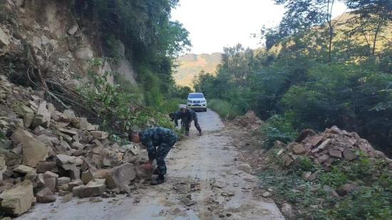 护矿队队员清理因泥石流而滑到路中的落石。黄佳逢供图